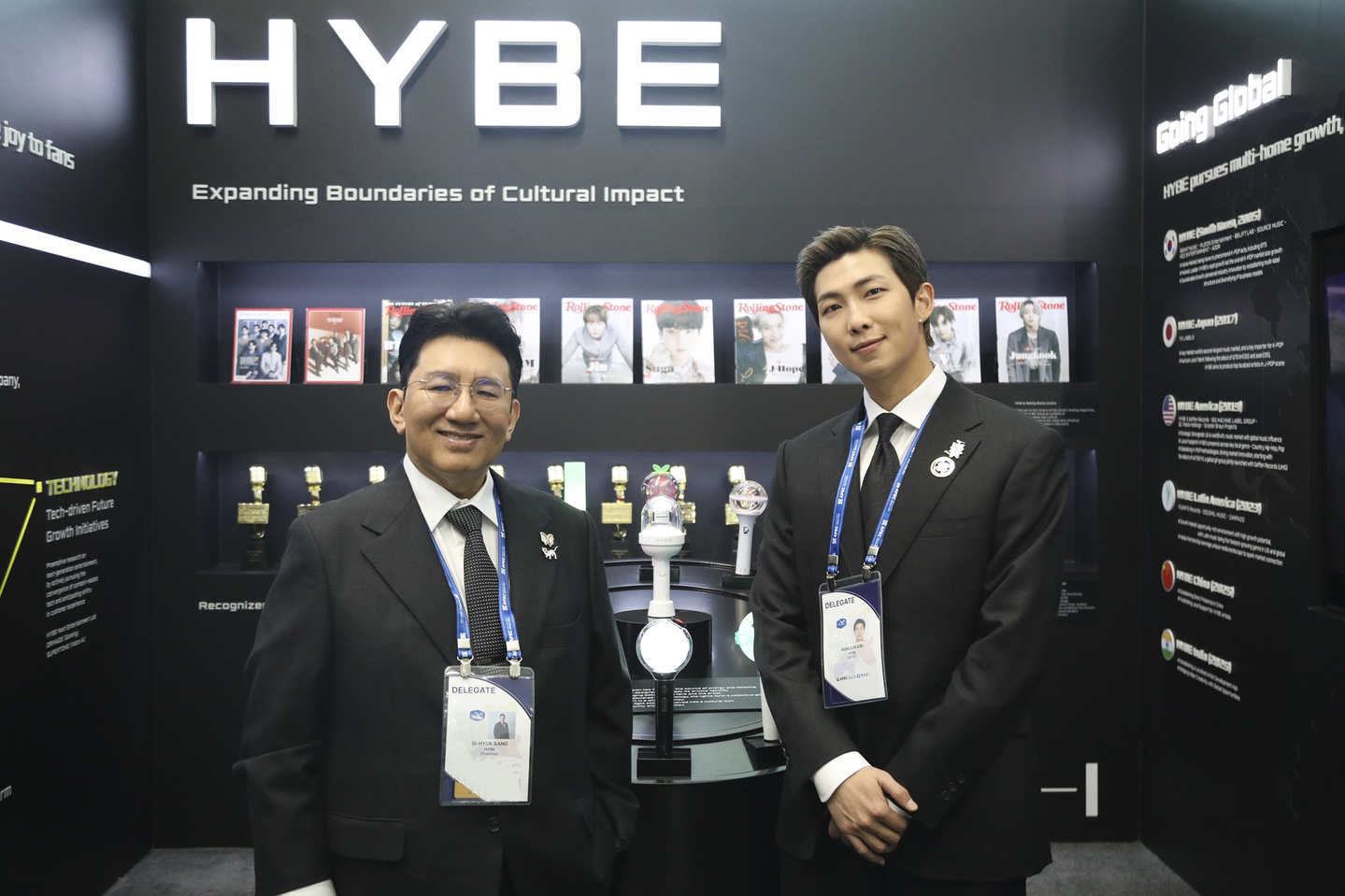 HYBE Chairman Bang Si-hyuk, left, and BTS member RM visit the HYBE promotional booth during the opening ceremony of the APEC CEO Summit at the Gyeongju Arts Center in North Gyeongsang on Oct. 29, 2025. [YONHAP]