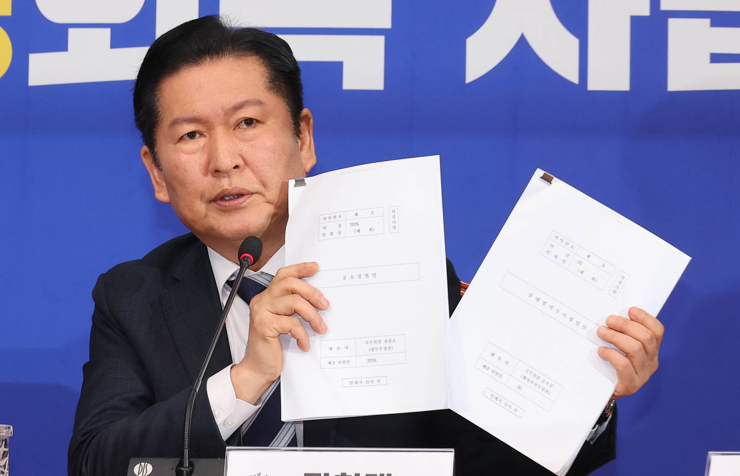 Democratic Party leader Jung Chung-rae speaks while holding bills on the Public Prosecution Office and the Serious Crimes Investigation Office during an emergency press conference on prosecution reform at the National Assembly in Seoul on the morning of March 17. [LIM HYUN-DONG]