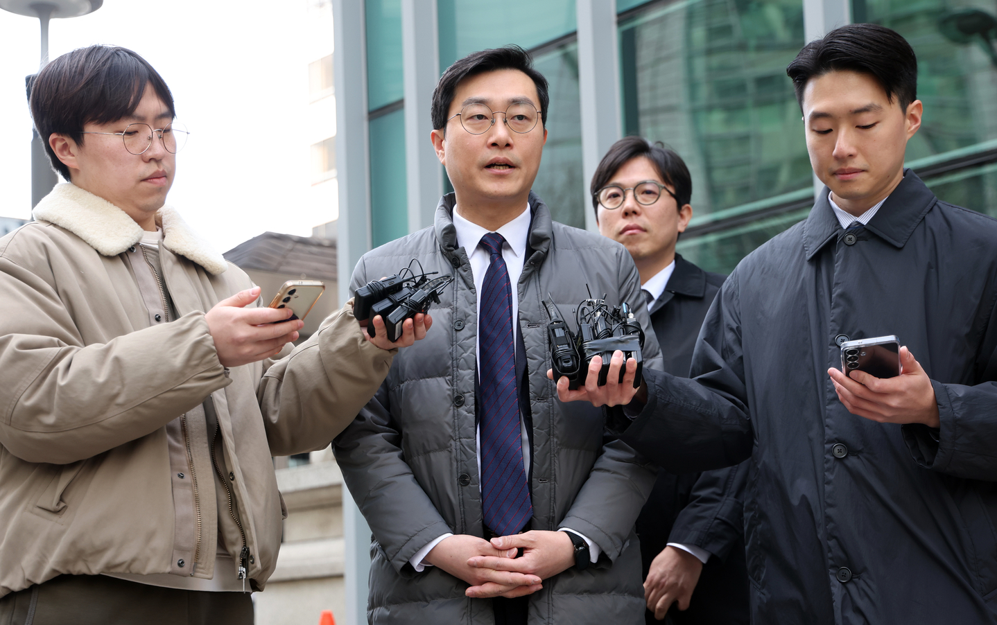 Rep. Jang Kyung-tae of the ruling Democratic Party, center, speaks to reporters outside the Seoul Metropolitan Police Agency in the capital to attend a meeting of an investigation deliberation committee on March 19. [NEWS1]