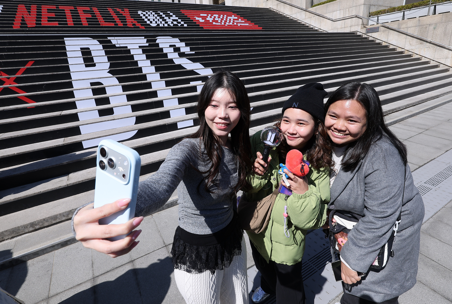 Fans of boy band BTS take a photo in front of a promotional installation for the band's comeback concert in Gwanghwamun Square in front of Sejong Center for the Performing Arts in Jongno District, central Seoul on March 19. [NEWS1]