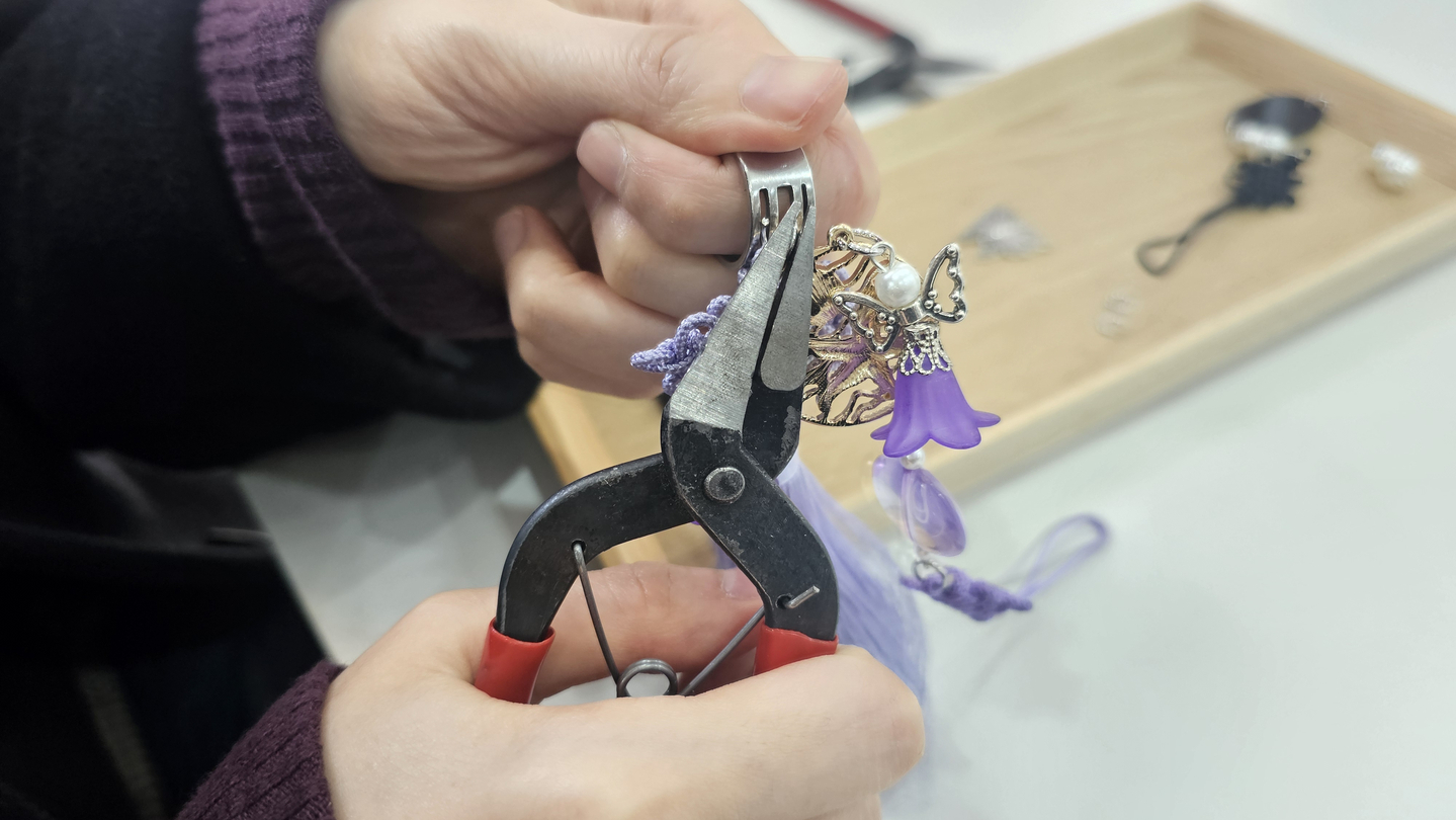 The reporter uses pliers to attach parts while making her own norigae tassel. [SHIN HA-NEE]