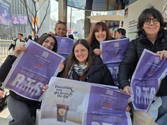 Fans pose with the BTS special edition of the Korea JoongAng Daily in central Seoul on March 21. [KIM MIN-YOUNG]