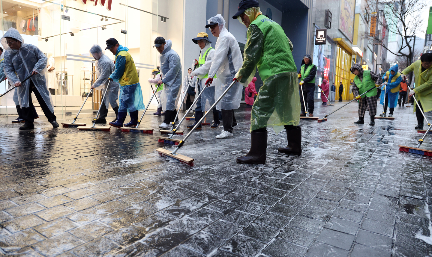 District office workers and local merchants carry out street cleaning in Myeongdong, Jung District, central Seoul, on March 18, ahead of BTS’s concert on March 21 and the spring tourist season. [NEWS1]