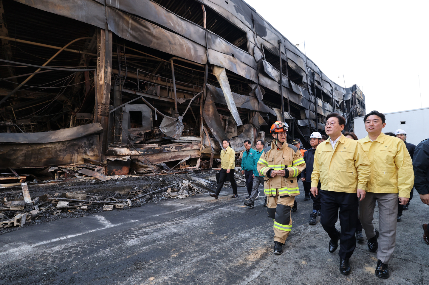 President Lee Jae Myung, second from right, is briefed as he visits the site of a blaze at an auto parts factory in Daejeon on March 21. [JOINT PRESS CORPS] 