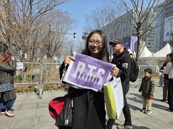 A fan poses with the BTS special edition of the Korea JoongAng Daily in central Seoul on March 21. [KIM MIN-YOUNG]