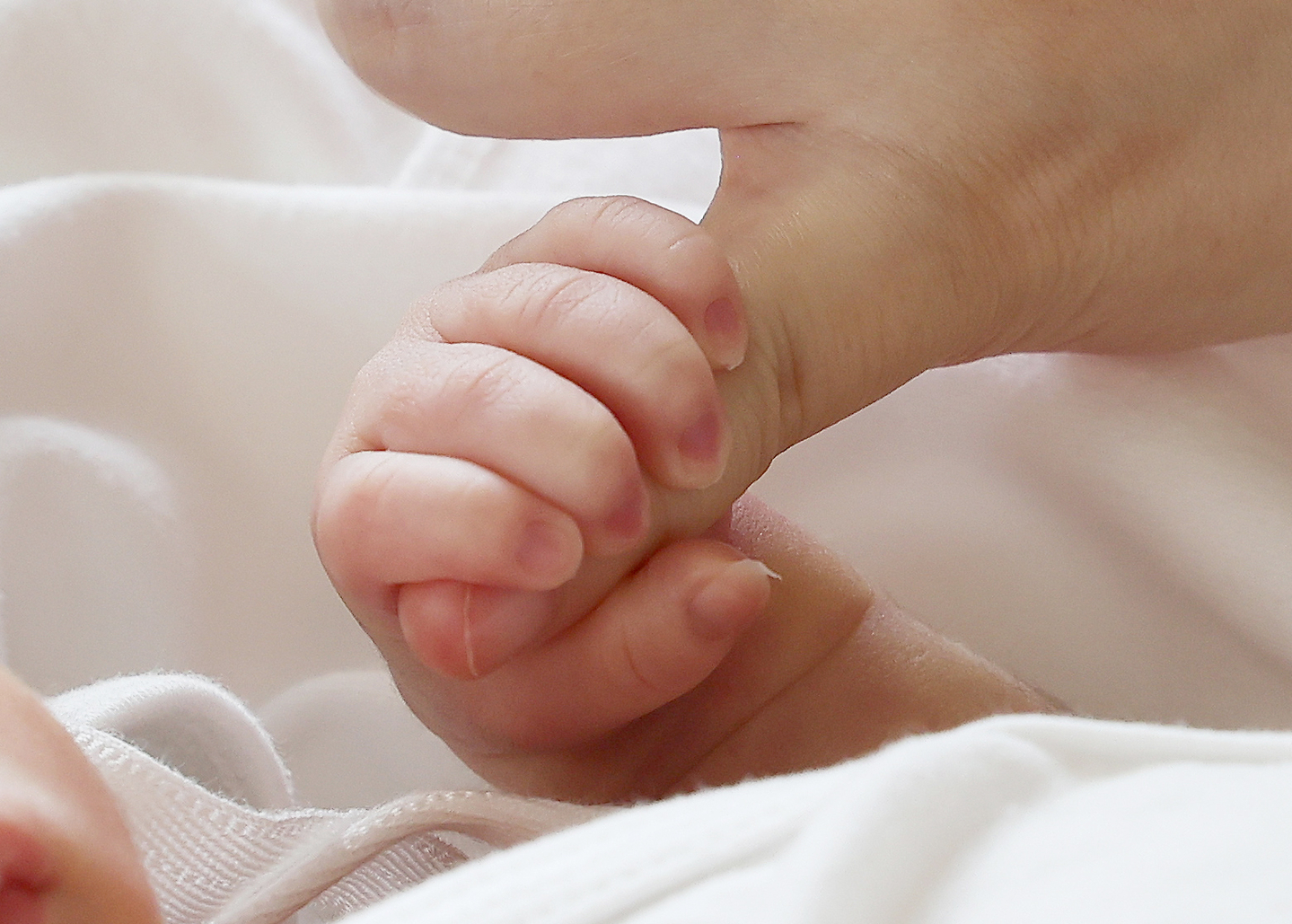 A newborn holds the finger of its mother at a hospital in Suwon, Gyeonggi, on July 11, 2024. [YONHAP]