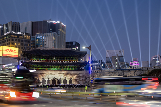 The seven BTS members are projected onto Sungnyemun in central Seoul on March 20.  [JOONGANG ILBO]