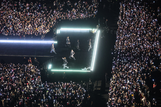 Boy band BTS performs during its comeback performance at Gwanghwamun Square in central Seoul on March 21. Dense crowds of fans and concertgoers surround the stage. [JOINT PRESS CORPS]
