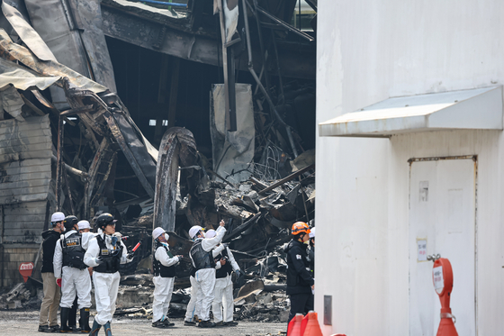 Investigators are seen outside an auto parts factory in Daedeok District, Daejeon on March 22, after a fire broke out at the facility on March 20. [NEWS1]
