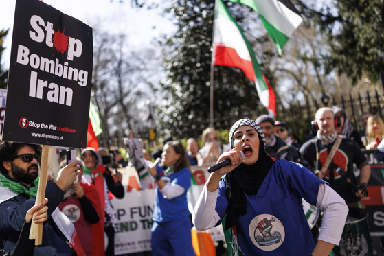 People display placards, wave flags and chant as they attend the 'Stop Bombing Iran' march to Whitehall in London on March 21. [EPA/YONHAP] 