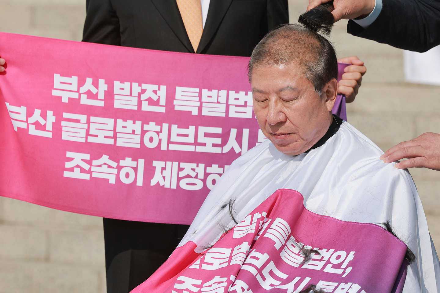 Busan Mayor Park Heong-joon shaves his head, demanding the swift passage of a special bill aimed at transforming the southeastern port city of Busan into a global hub city in front of the National Assembly in western Seoul on March 23. [YONHAP]