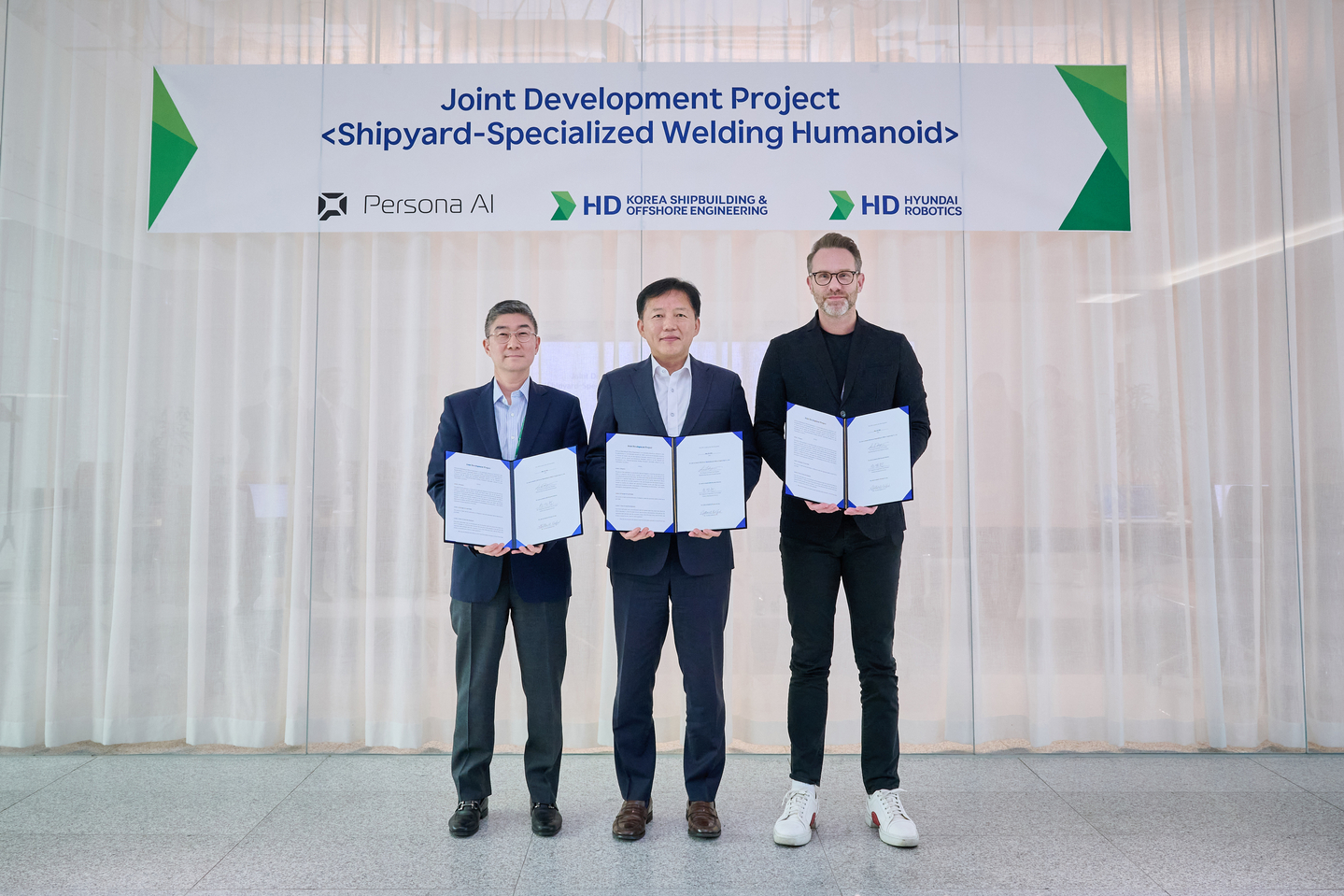 From left to right, Song Young-hoon, head of the solutions development division at HD Hyundai Robotics; Lee Dong-joo, head of the manufacturing innovation institute at HD KSOE and Persona AI CEO Nick Radford pose for a commemorative photo at HD Hyundai's global research and development center in Pangyo, Gyeonggi, after the companies signed a partnership agreement to develop AI-powered humanoid welding robots, in this photo provided by HD Hyundai on March 23. [HD HYUNDAI]