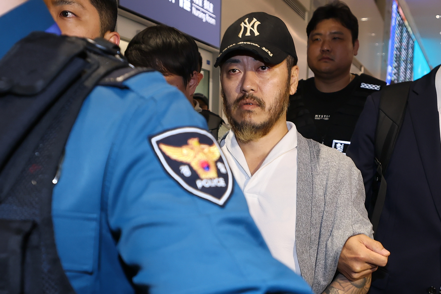 Park Wang-yeol, center, a convicted criminal accused of smuggling drugs into Korea, is escorted by police officials at Incheon International Airport on March 25. [JOINT PRESS CORPS]