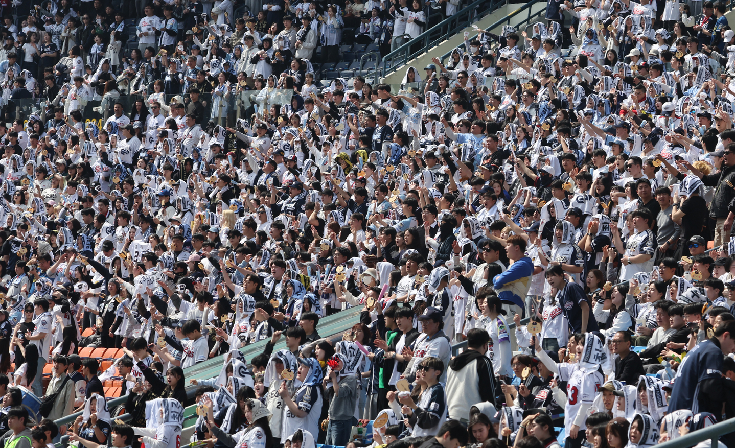 Fans cheer during a preseason game between the Doosan Bears and the KIA Tigers at the Jamsil Baseball Stadium in Songpa District, southern Seoul, on March 22. [YONHAP]