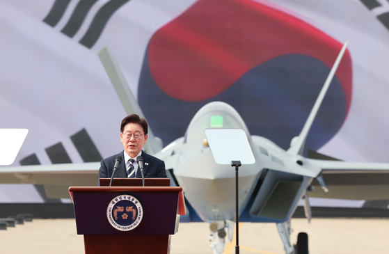 President Lee Jae Myung speaks in front of the KF-21 at the launch ceremony of the fighter jet on March 25 at the Korea Aerospace Industries headquarters in Sacheon, South Gyeongsang. [NEWS1]