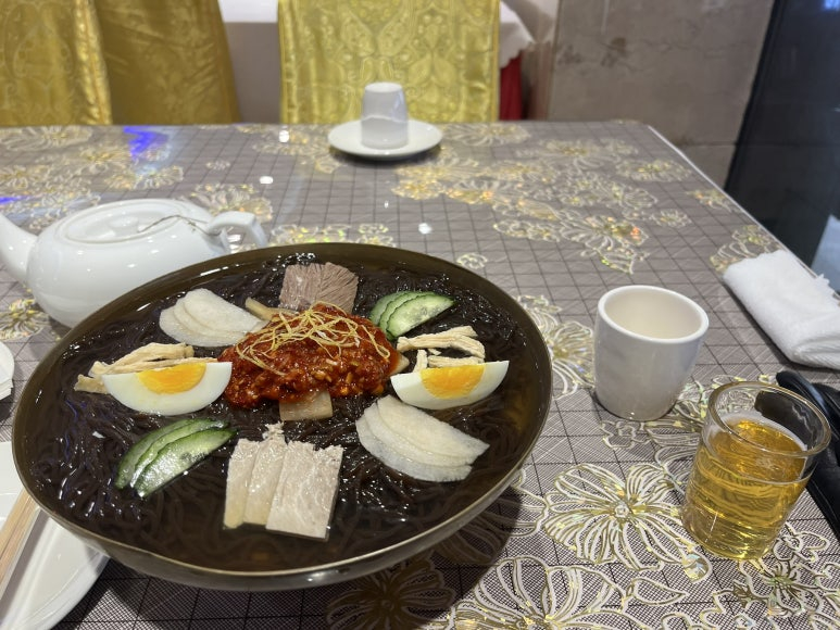 A bowl of North-Korean style naengmyeon (cold noodles) and glass of Taedonggang beer are seen in a photo taken at Morangwan Restaurant in Shenyang, China, in 2025. [LEE JONG-SUK]