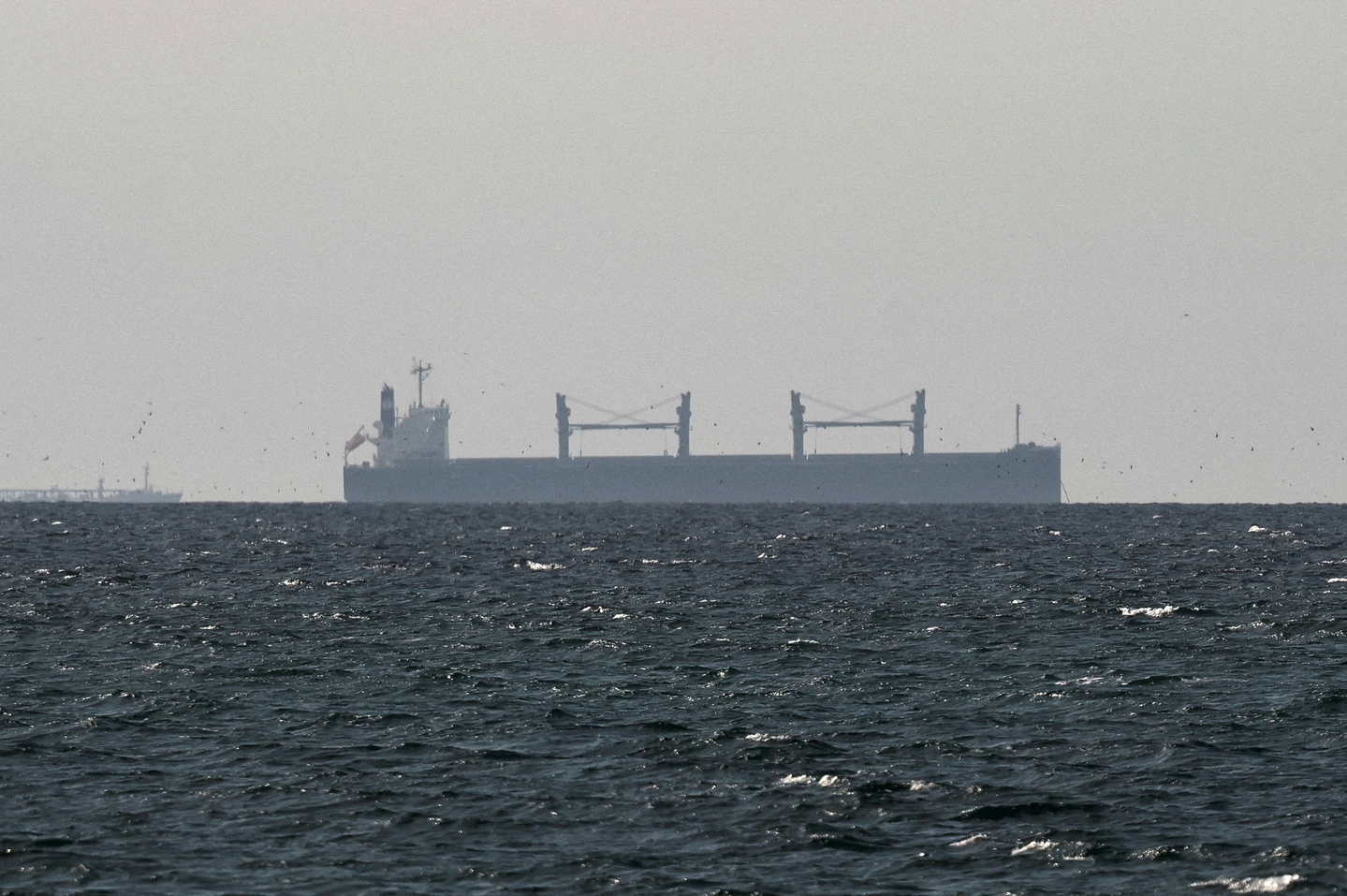 A cargo ship in the Gulf, near the Strait of Hormuz, as seen from northern Ras al-Khaimah, near the border with Oman’s Musandam governance, amid the U.S.-Israeli conflict with Iran, in United Arab Emirates on March 11. [REUTERS/YONHAP]
