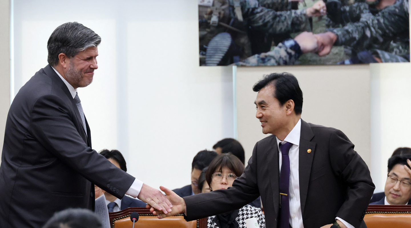 Defense Minister Ahn Gyu-back, right, and Canadian Ambassador to Korea Philippe Lafortune shake hands at the National Assembly in Yeouido, western Seoul, on March 24. [YONHAP] 