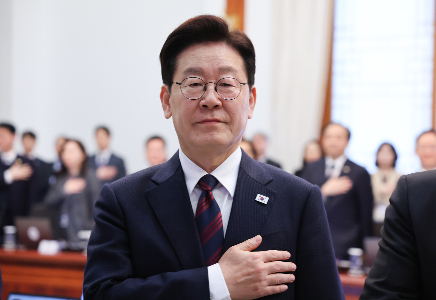 President Lee Jae Myung salutes the national flag during a meeting with his senior secretaries at the presidential office in Seoul on March 19. [YONHAP] 