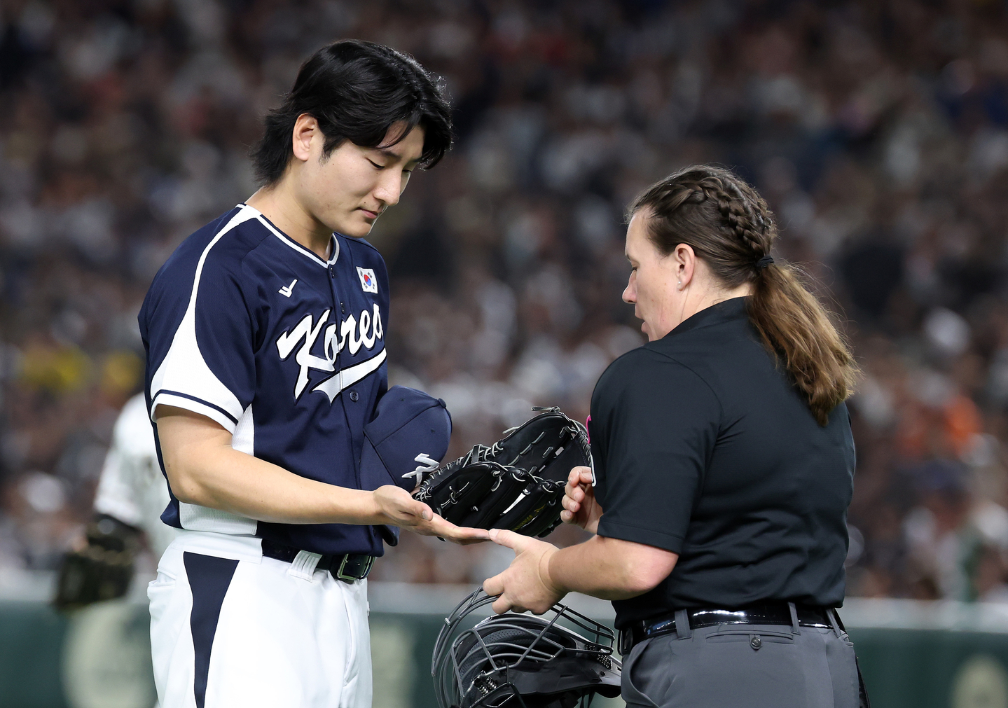 Korean pitcher Gwak Been, left, has his hands checked for illegal substances by home plate umpire Jen Pawol during an exhibition game against Japan at the Tokyo Dome in Tokyo, in this Nov. 15, 2025, file photo. [YONHAP]
