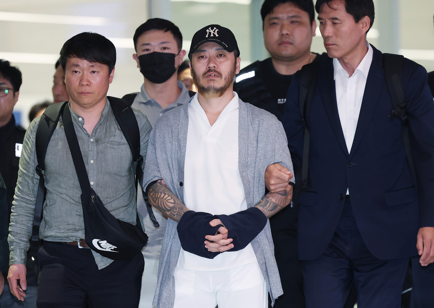 Park Wang-yeol, a suspected drug kingpin who killed three Korean nationals in the Philippines, escaped prison and allegedly trafficked narcotics into Korea, is escorted through Incheon International Airport on March 25. [YONHAP]