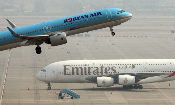 Korean Air and Emirates planes are seen at Incheon International Airport on March 16. [YONHAP] 