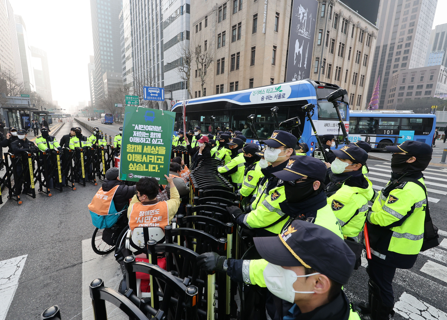 Members of the civic group Solidarity Against Disability Discrimination are sealed off by police during the group's protest on Sejong-daero, a street in Jongno District, central Seoul, on March 27. [YONHAP]