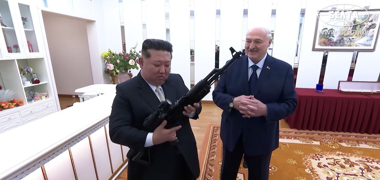 North Korean leader Kim Jong-un, left, holds up an assault rifle given by Belarusian President Aleksandr Lukashenko during his state visit in Pyongyang on March 26 in this screen grab from Belarus's news agency BelTA. [SCREEN CAPTURE]