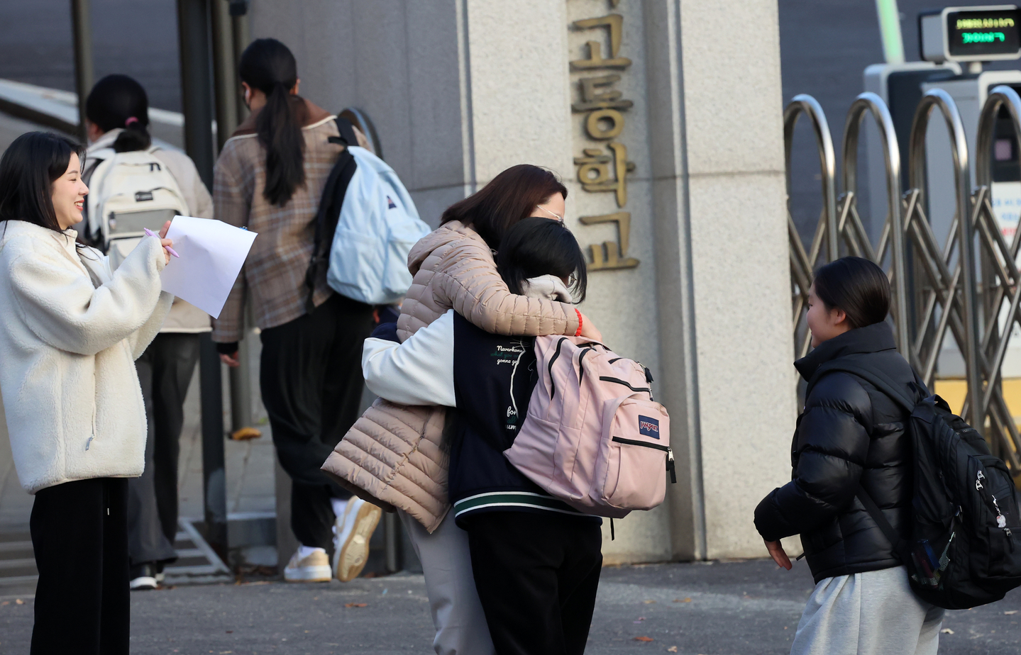 A teacher at Gangil Girls' High School in Gangneung, Gangwon, hugs a student before entering the building to take the 2026 College Scholastic Ability Test (CSAT) on Nov. 13. [YONHAP]