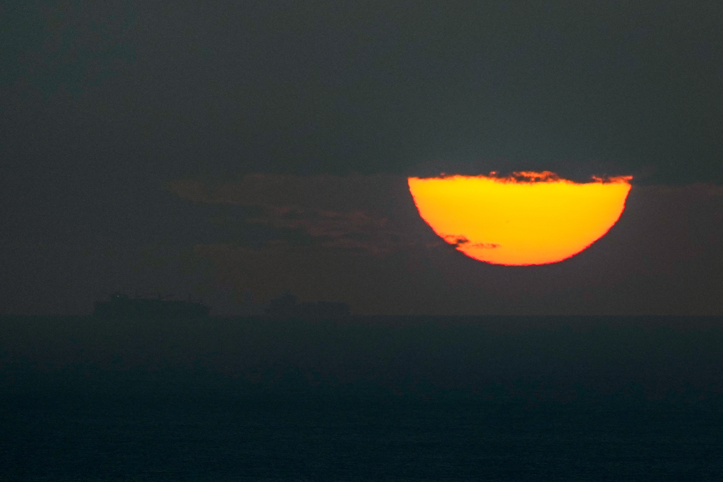 Ships sail through the Arabian Gulf toward the Strait of Hormuz as the sun sets in the United Arab Emirates on March 23, 2026. [AP/YONHAP]