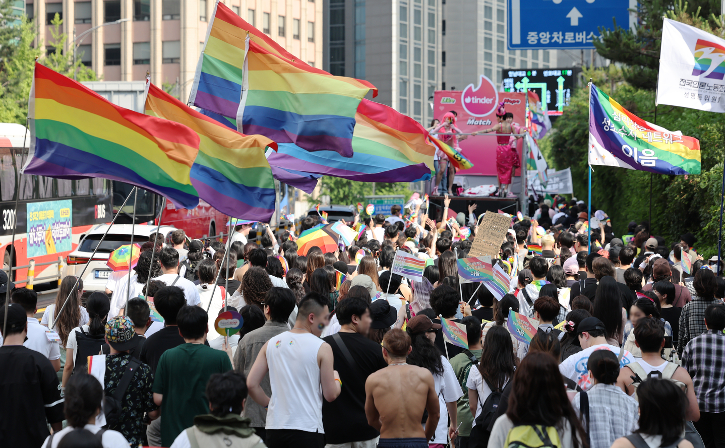 Participants in the 26th Seoul Queer Culture Festival hold up rainbow flags as they march up a road near Myeongdong Cathedral in Jung District, central Seoul, on June 14, 2025. [NEWS1]