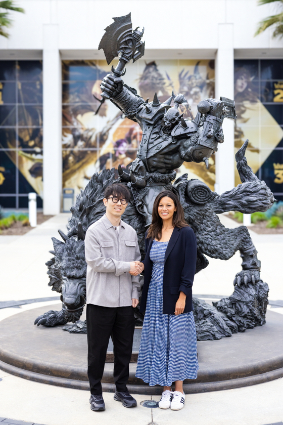 Nexon Korea Co-CEO Kang Dae-hyun, left, shakes hands with Johanna Faries, president of Blizzard Entertainment. [NEXON]