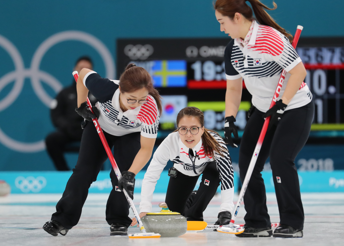 Skip Kim Eun-jung delivers a stone during the women’s curling final at the 2018 PyeongChang Winter Olympics between Korea and Sweden at the Gangneung Curling Centre in Gangneung, Gangwon, on Feb. 25, 2018. From left: Kim Seon-yeong, Kim Eun-jung and Kim Yeong-mi. [YONHAP]