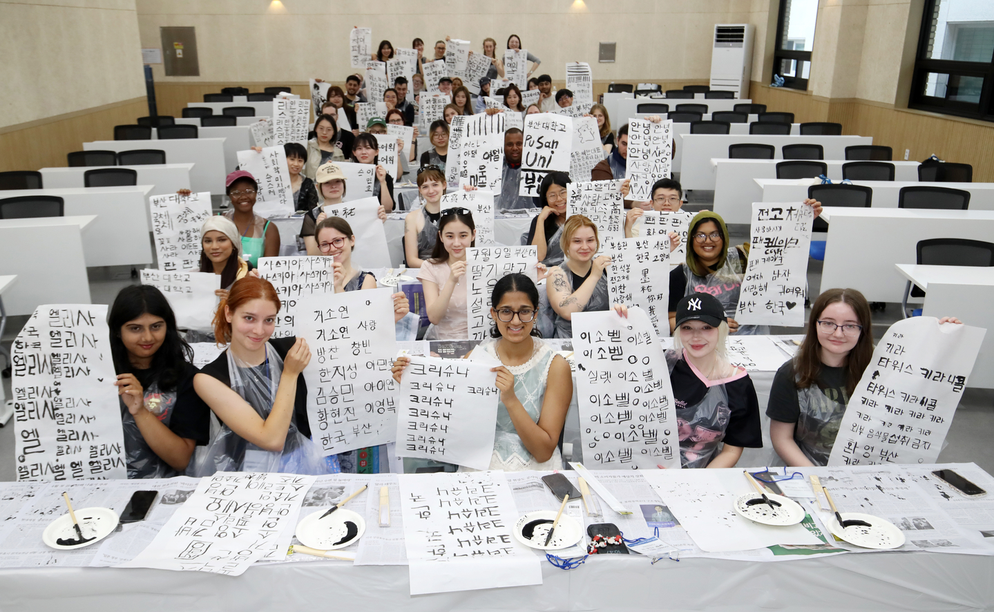 International students hold up their brush calligraphy works during a traditional calligraphy experience session at the “2025 Pusan National University Summer School,” held on July 9, 2025 at Pusan National University in Geumjeong District, Busan.