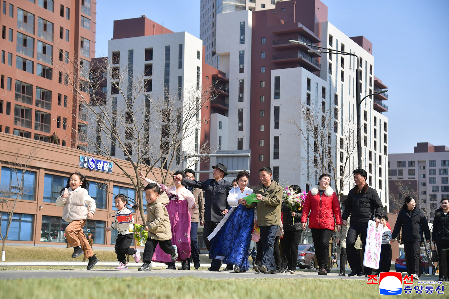 Residents are seen in front of apartment buildings in Pyongyang's newly refurbished Hwasong district, in this image published by the state-run Korean Central News Agency on March 18. [YONHAP]
