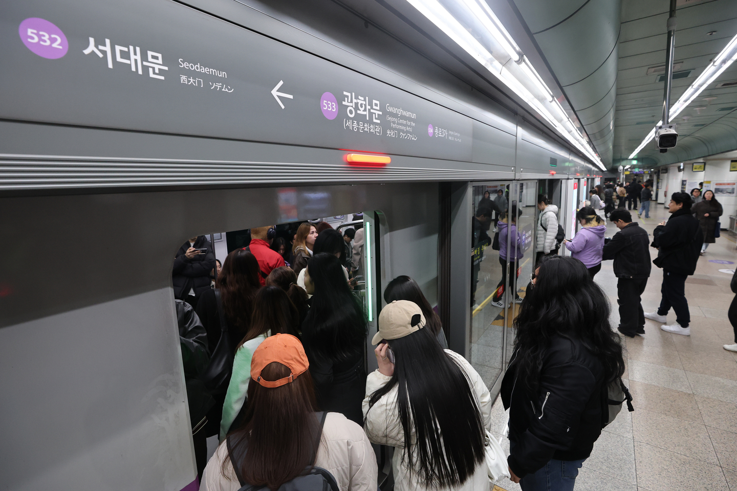 Commuters and passengers board a subway train at Gwanghwamun Station on Line No. 5 in central Seoul on March 21. [YONHAP]   