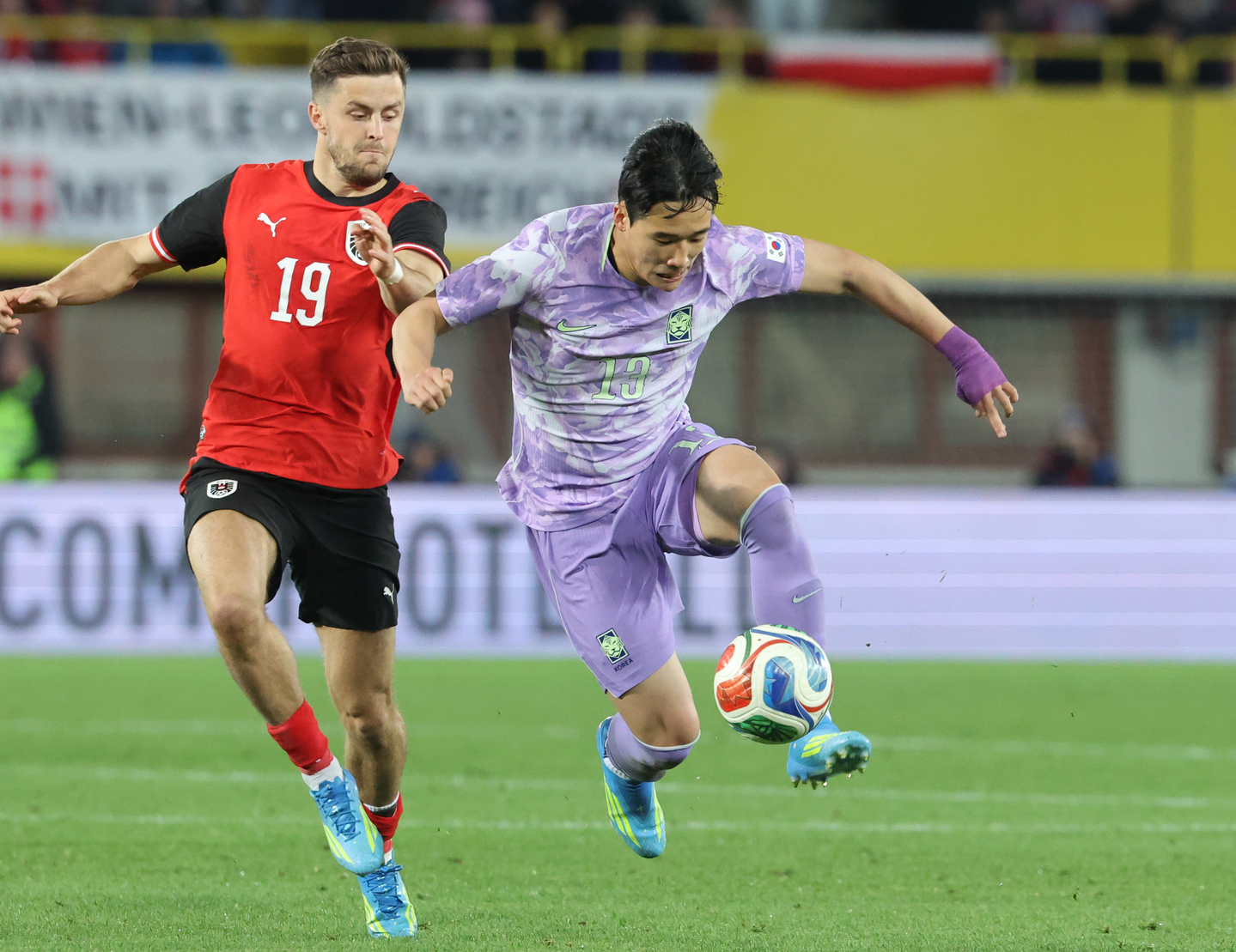 Lee Tae-seok, right, tries to run past Christoph Baumgartner of Austria during the teams' friendly football match at Ernst-Happel-Stadion in Vienna on March 31, 2026. [YONHAP] 