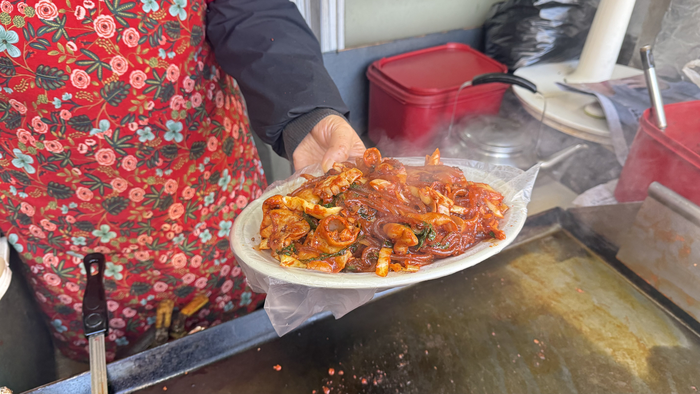 A server holds a plate of vegetable gopchang (intestines). [WOO JI-WON]