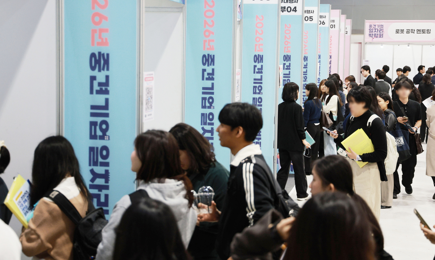 Job seekers look around company booths at the 2026 medium-sized company job fair at the aT Center in Seocho District, southern Seoul, on March 31. [YONHAP]