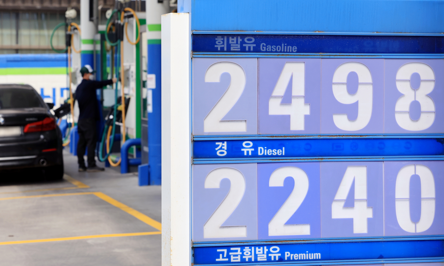 An employee fuels a vehicle at a gas station in Seoul on March 30. [NEWS1]