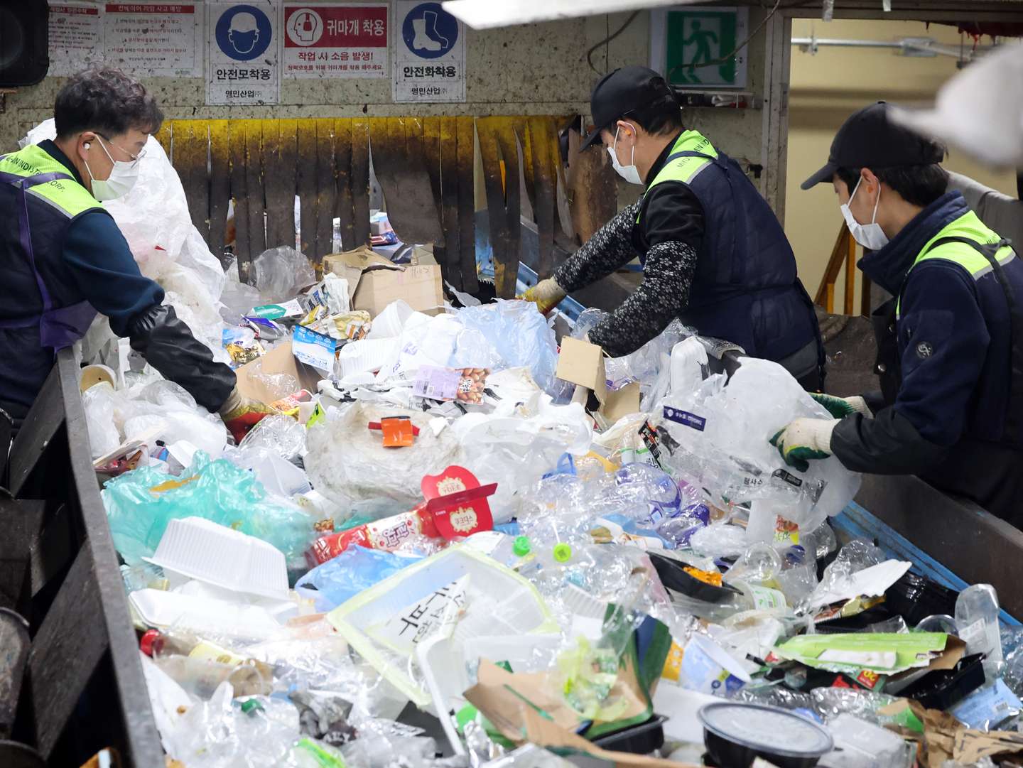 Workers sort recyclable waste at a recycling center in Dobong District, northern Seoul, on Jan. 26. [NEWS1]