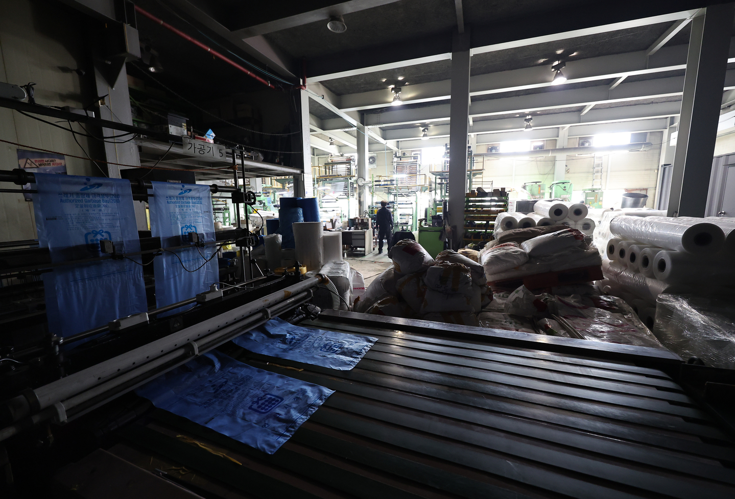 Lights are turned off at a processing workstation inside a plastic bag manufacturing factory in Ansan, Gyeonggi, on March 24. Production has been temporarily scaled back due to a shortage of raw materials like polyethylene. Korean petrochemical firms have cut production following disruptions in naphtha imports caused by the ongoing conflict in the Middle East. [YONHAP]