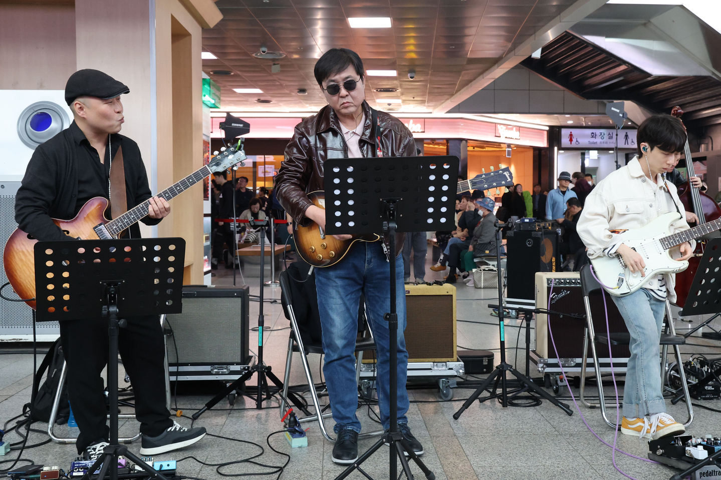 Minister of Culture, Sports and Tourism Chae Hwi-young, center, plays the guitar during a performance at Seoul Station in Jung District, central Seoul, on April 1 as part of an event marking the expansion of the government's monthly cultural discount day to every Wednesday. [NEWS1]