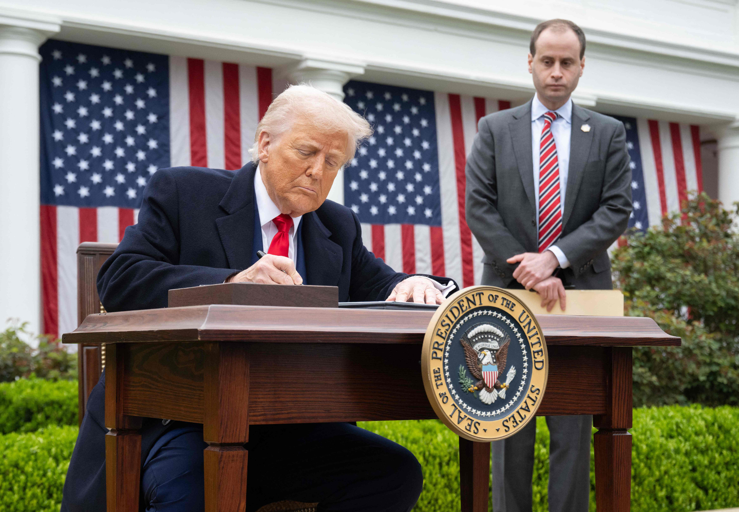 U.S. President Donald Trump signs an executive order after delivering remarks on reciprocal tariffs during an event in the Rose Garden entitled ″Make America Wealthy Again″ at the White House in Washington on April 2, 2025. [AFP/YONHAP]