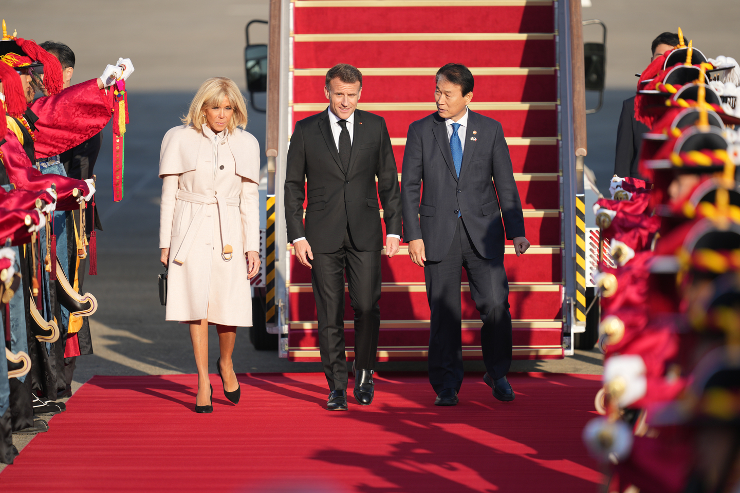 French President Emmanuel Macron, center, and his wife Brigitte Macron, left, inspect an honor guard with Korean Minister of Patriots and Veterans Affairs Kwon Oh-eul, right, at the Seoul Air Base in Seongnam, Gyeonggi, on April 2. [AP/YONHAP]