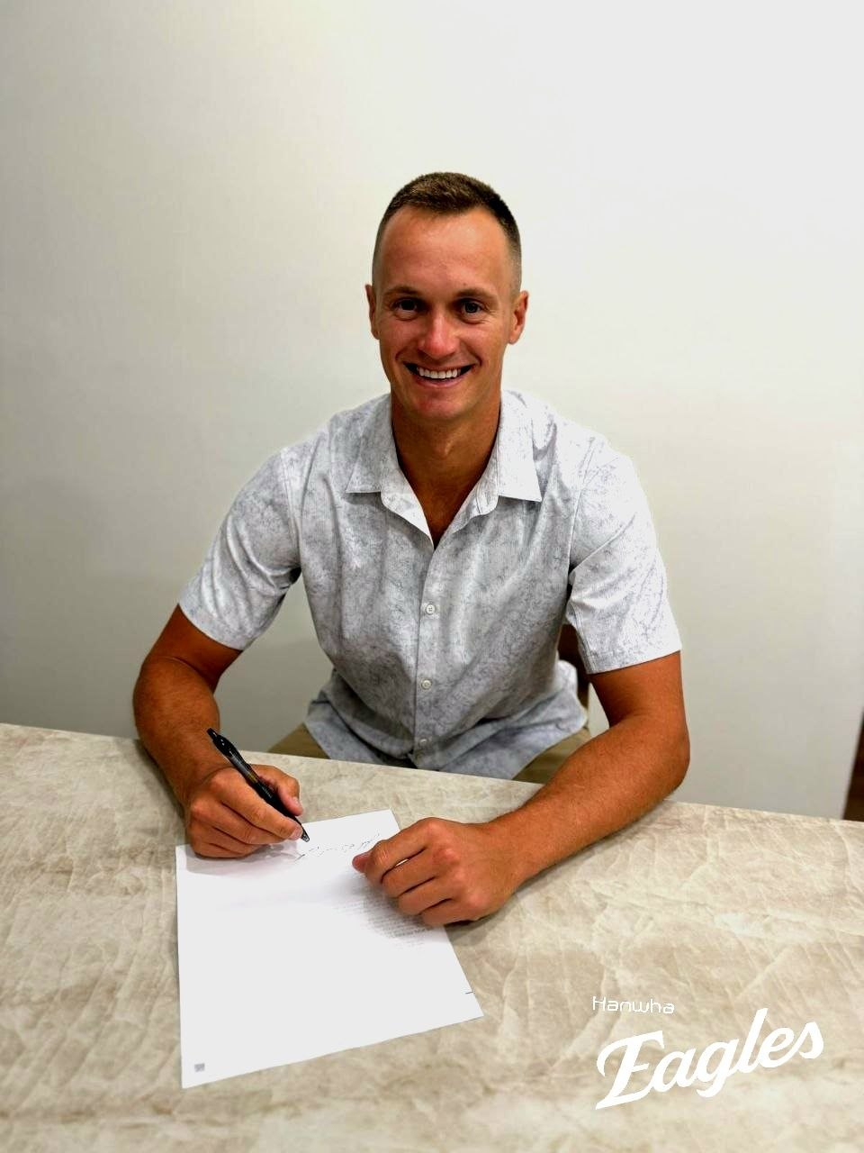 New Hanwha Eagles pitcher Jack Cushing signs his six-week contract with the KBO club, in this photo provided by the Eagles on April 4. [YONHAP] 