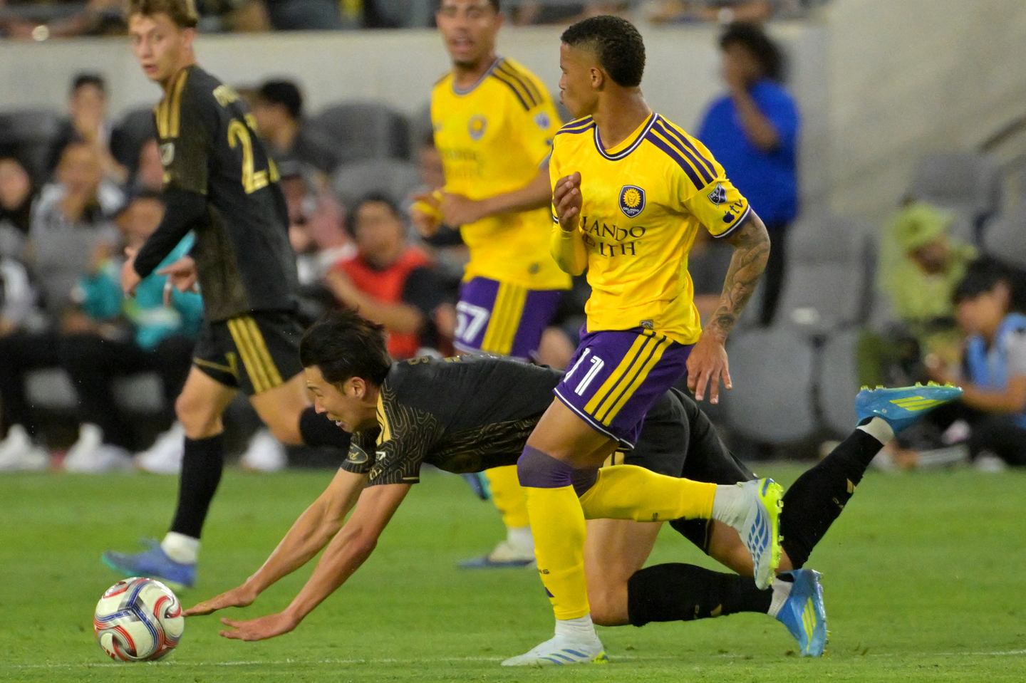 Los Angeles FC forward Son Heung-min gets tripped up by Orlando City forward Tiago during an MLS fixture at BMO Stadium in Los Angeles on April 4. [REUTERS/YONHAP] 