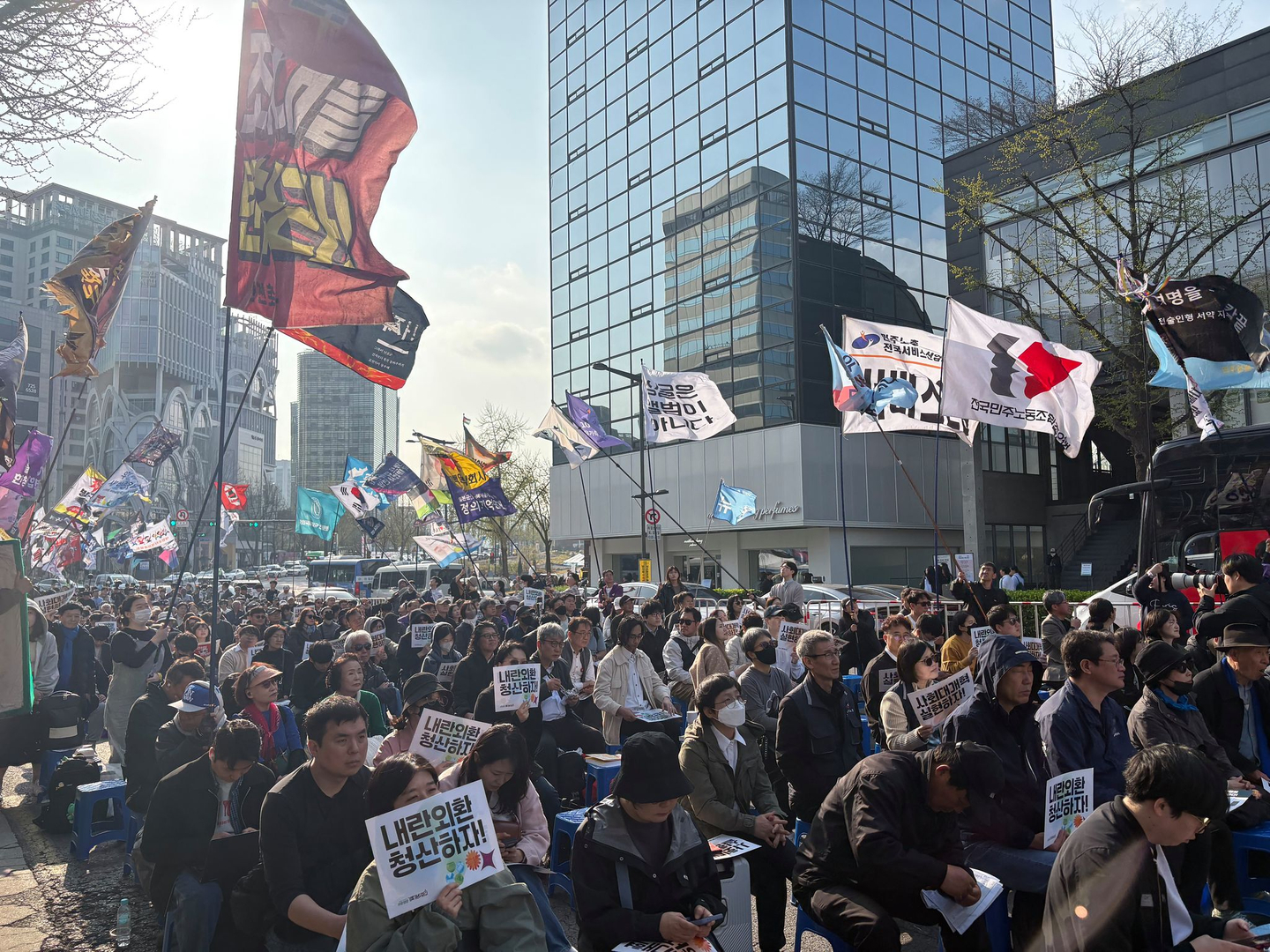 People wave signs and flags at exit 6 of Anguk Station near the Constitutional Court of Korea in Jongno District, central Seoul, on April 4 during a rally marking the first anniversary of former President Yoon Suk Yeol’s impeachment. [KIM YE-JUNG]