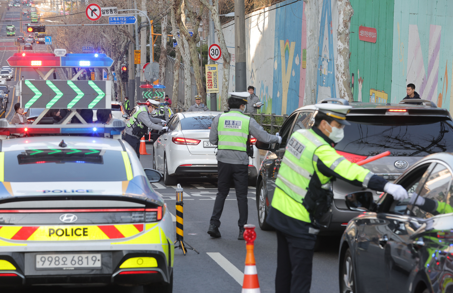 Police conduct drunk driving tests outside Yanggang Elementary School in Yangcheon District, western Seoul, on March 4. [YONHAP]