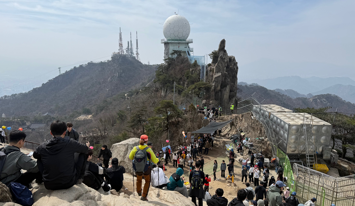 Hikers crowd Mount Gwanak’s Yeonjudae on April 5. [WOO JI-WON]